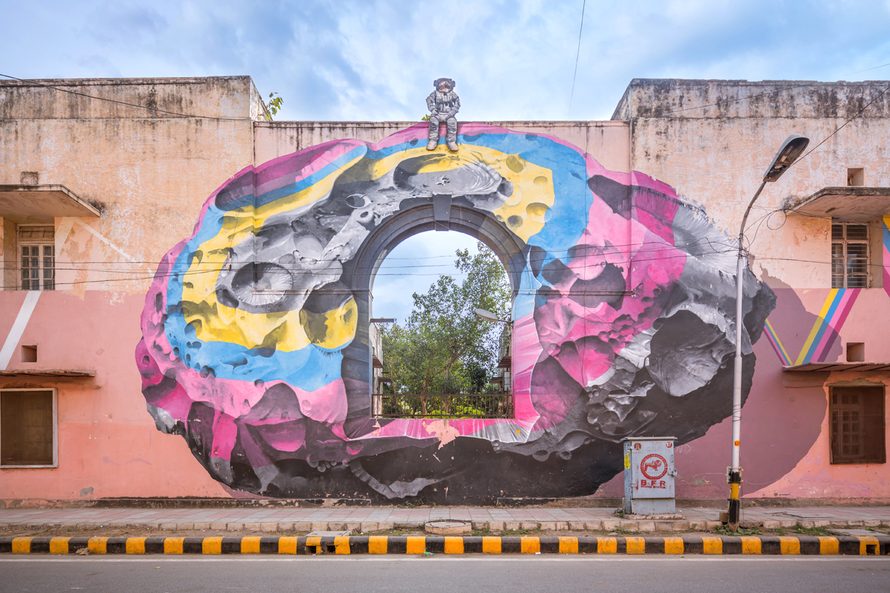 Astronaut and a colourful meteorite by Nevercrew - a metaphor for someone who can see things from a different perspective - The City Is Their Canvas