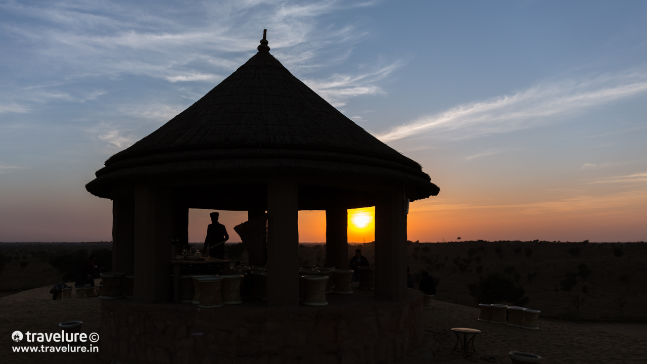 On both sides of this mound, there lay a grey-ish amoeboid water body. The banks farther away from us were carpeted with thousands of birds constantly buzzing around in a slow Brownian motion! - Flying Through The Sands - Travelure © #SandDunes #DemoisellesCranes #KhajurahoOfRajasthan #Khichan