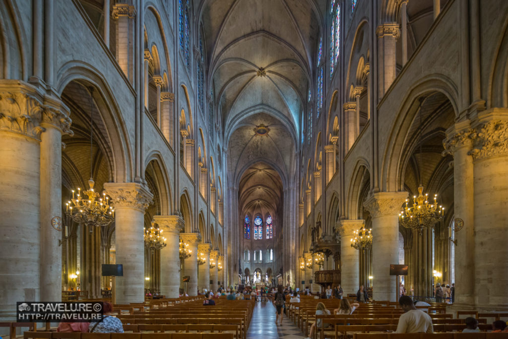 Notre-Dame nave. Pews alongside as the aisle leads to the altar. - Travelure ©