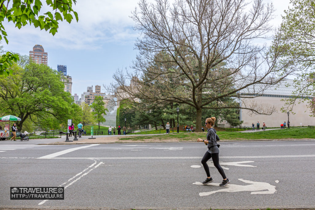 Jogger inside the Central Park. Met Museum is in the background. - Travelure ©