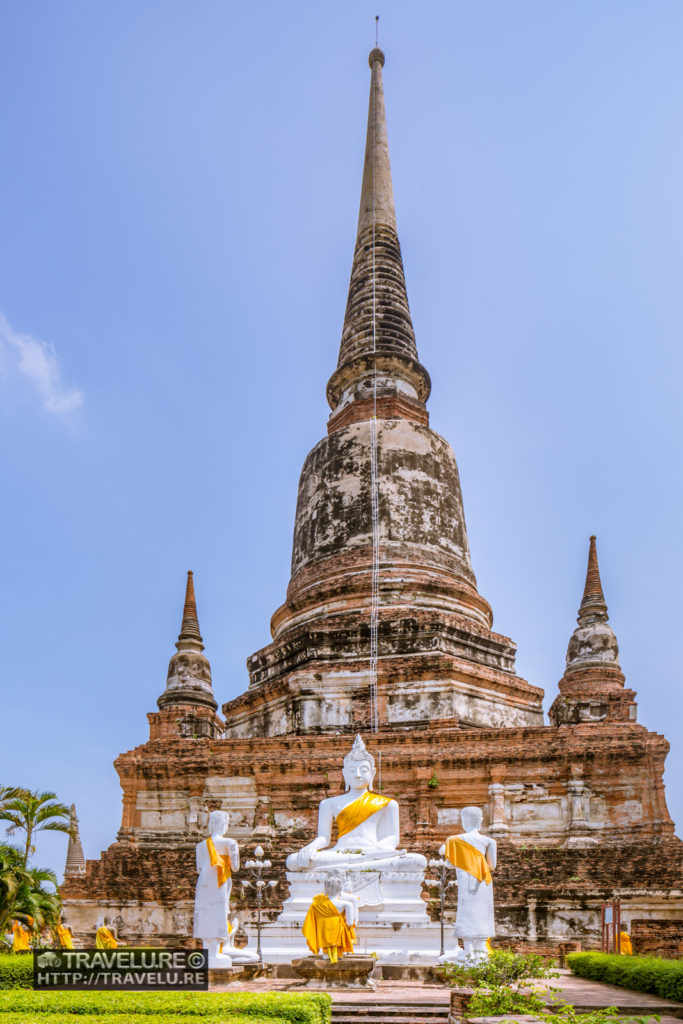 An imposing Buddha statue, with Wat Yai Chai Mongkhon providing an equally imposing backdrop - Travelure ©