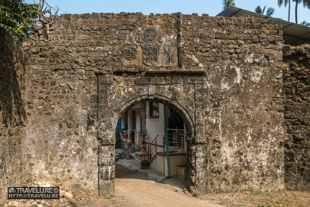 The inside entrance arch with Portuguese coat of arms. You can see the modern-day structures through the arch - Travelure ©